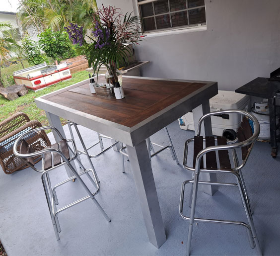 An outdoor patio scene with a metal table and four metal chairs in Miami FL