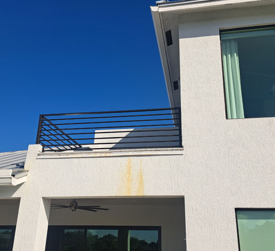 A white house with a balcony and an elegant hand rail installation Boca Raton in the second floor