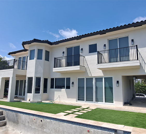 A big white house that has three balconies with top rail fence West Palm Beach installations