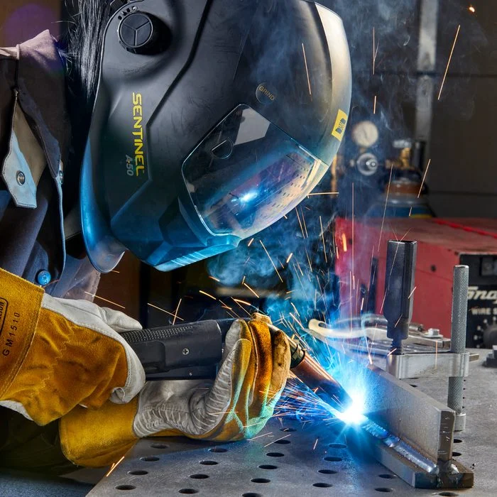 Welder performing precision welding on a custom metal fabrication project