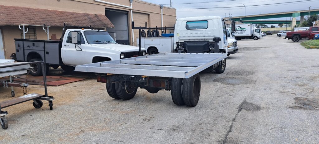 Custom flatbed trailer with aluminum frame and wheels in workshop setting 2